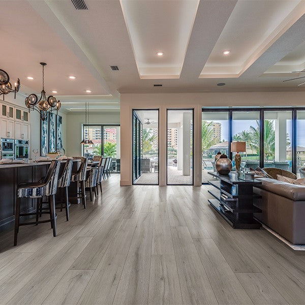 Light gray wood-look vinyl flooring in modern open-concept living space with coastal view
